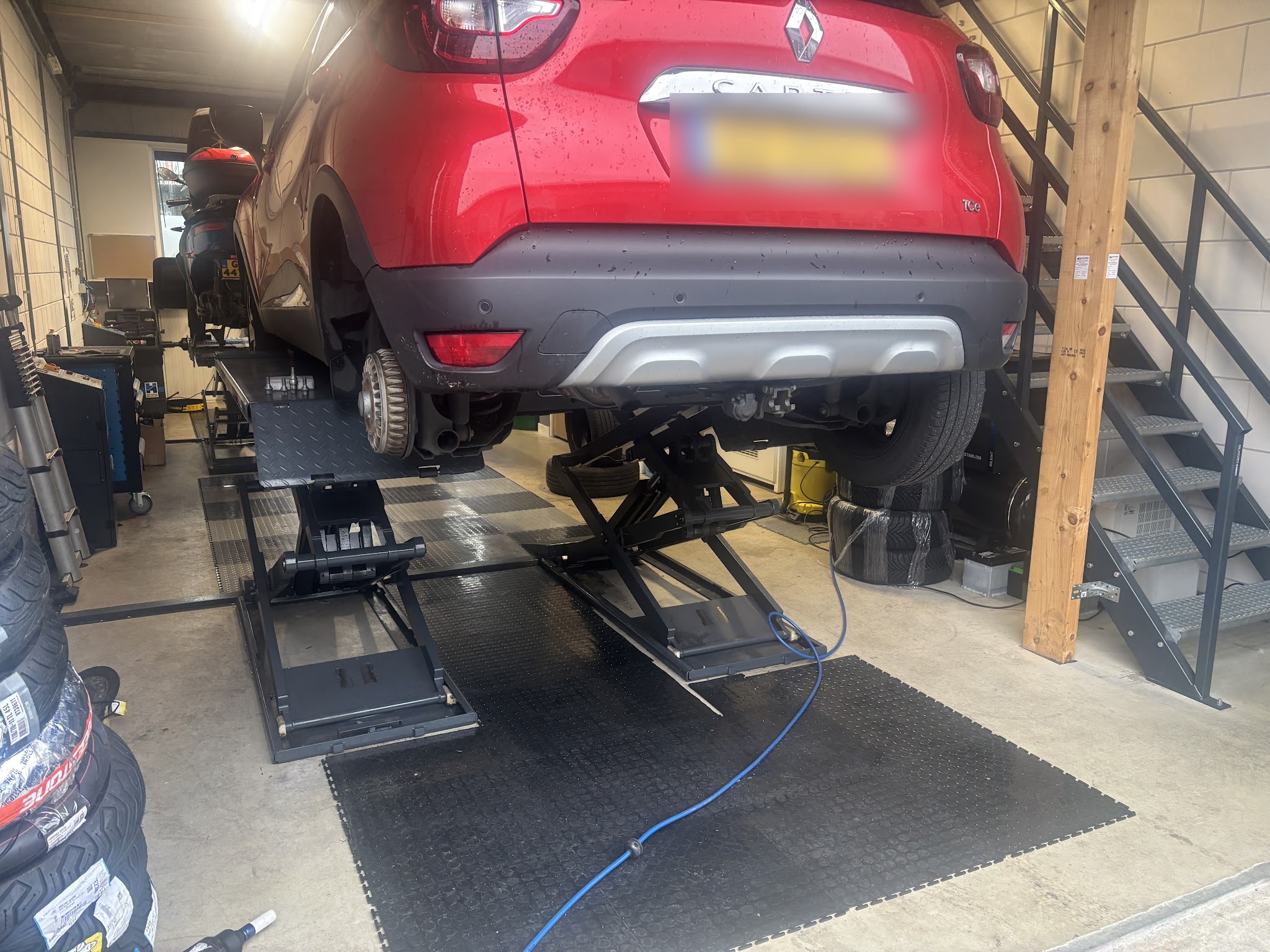 Rode Renault Captur op de brug in de werkplaats