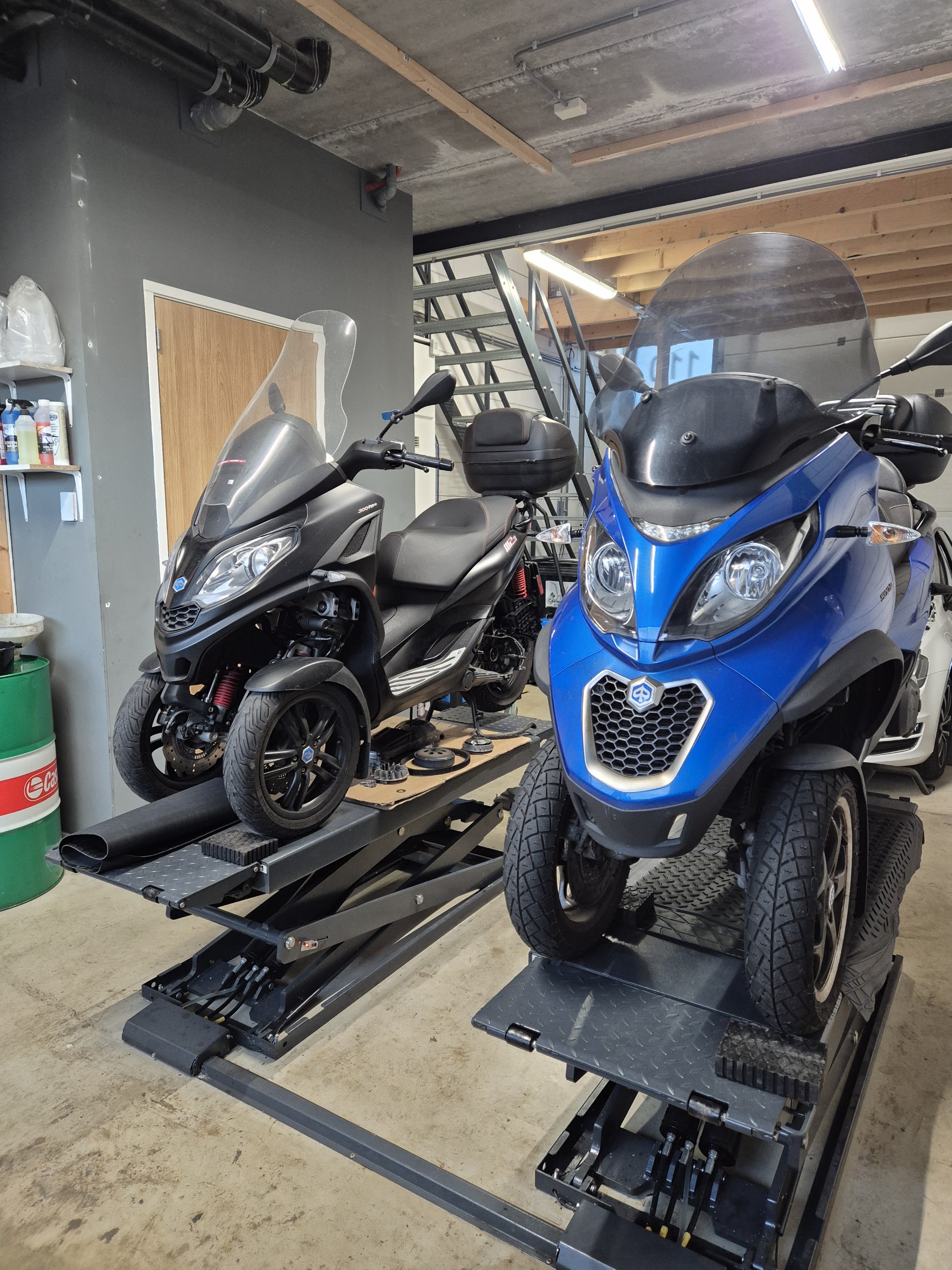 Twee Piaggio MP3 driewielscooters op de brug in de werkplaats